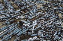 Un procureur observe des pièces collectées de roquettes russes utilisées pour attaquer la ville de Kharkiv, Ukraine, jeudi 22 décembre 2022.