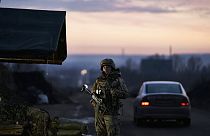 Egy ukrán katona áll egy ellenőrzőpontnál, miközben a nap lenyugszik Kramatorszkban, Donyeck régióban, Ukrajnában, 2022. december 22-én.
