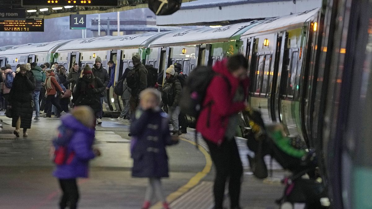 Пассажиры заходят в поезд на станции в Лондоне