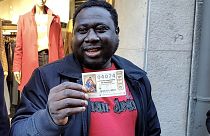 Ibrahim con el billete de lotería que ha resultado premiado