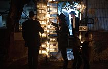 Ultraortodox zsidó szemináriumi hallgatók gyertyát gyújtanak hanuka ötödik estéjén Jeruzsálem Mea Shearim negyedében 2022. december 22-én
