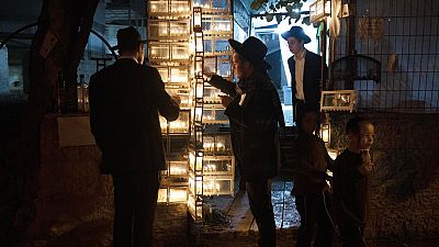 Ultraortodox zsidó szemináriumi hallgatók gyertyát gyújtanak hanuka ötödik estéjén Jeruzsálem Mea Shearim negyedében 2022. december 22-én
