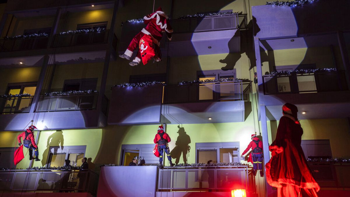 Firefighters dressed as Santas as they scale down Athens' main children's hospital to deliver presents to young cancer patients in Athens, Thursday, Dec. 22, 2022.