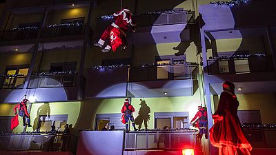 Firefighters dressed as Santas as they scale down Athens' main children's hospital to deliver presents to young cancer patients in Athens, Thursday, Dec. 22, 2022.