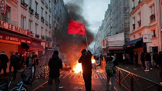 members of Kurdish community waves the Kurdish communist flags next to a barricade on fire at the crime scene where a shooting took place in Paris, Friday, Dec. 23, 2022. 