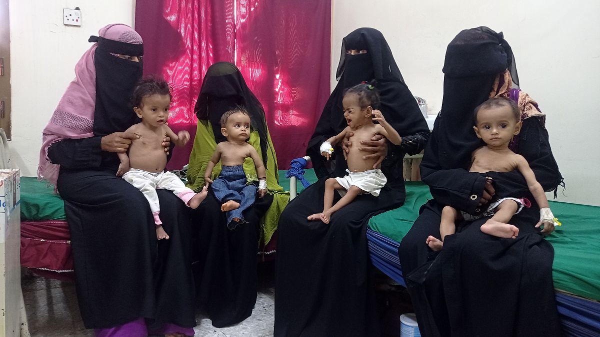 يمنيات يحملن أطفالهن الذين يعانون من سوء التغذية في مستشفى حيس الريفي في الحديدة، اليمن