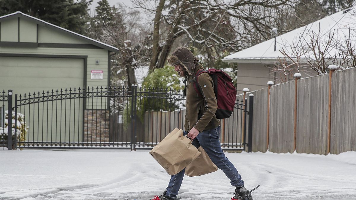 Πολίτης μετακινείται με χιονοπέδιλα σε παγωμένο δρόμο στις ΗΠΑ