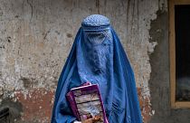 یک زن ۴۰ ساله افغان پس از خروج از یک مرکز زیرزمینی سوادآموزی در تاریخ ۳۰ ژوئیه ۲۰۲۲.