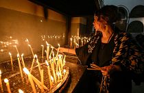 A woman lights candles inside the Church of the Nativity, traditionally believed to be the birthplace of Jesus Christ, in the West Bank town of Bethlehem,Saturday , Dec. 24, 2