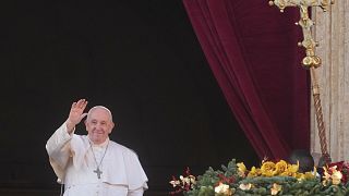 Pope Francis waves to faithful as he delivers the Urbi et Orbi Christmas day blessing from the main balcony of St. Peter's Basilic