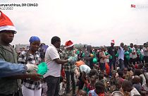 Helpers hand out food and drinks to displaced children in eastern DRC