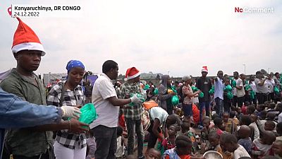 Helpers hand out food and drinks to displaced children in eastern DRC