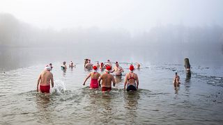 ألمان يسبحون في مياه بحيرة أورانكيسي التي يطفو عليها الجليد خلال عيد الميلاد في برلين. 2022/12/25