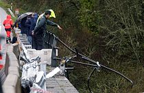 A civil guard points toward a bus after it plunged into a river near Pontevedra in northwestern Spain, Sunday, Dec. 25, 2022.
