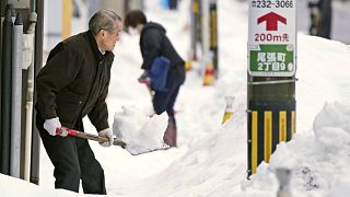 Residents shovel snow off a sidewalk in Kanazawa, central Japan.