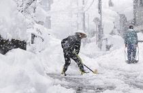 Varios vecinos quitan nieve de las calles en Japón. 