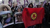 Activistas kurdas sostienen banderas y retratos mientras marchan en honor a las víctimas mortales del tiroteo sucedido en París. 