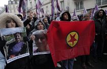 Activistas kurdas sostienen banderas y retratos mientras marchan en honor a las víctimas mortales del tiroteo sucedido en París. 