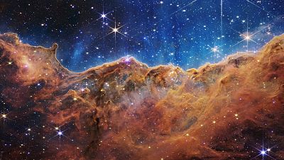 NASA tarafından 12 Temmuz 2022 günü yayınlanan fotoğraf, Karina Bulutsusu'ndaki genç, yıldız oluşum bölgesi NGC 3324'ün kenarını gösteriyor