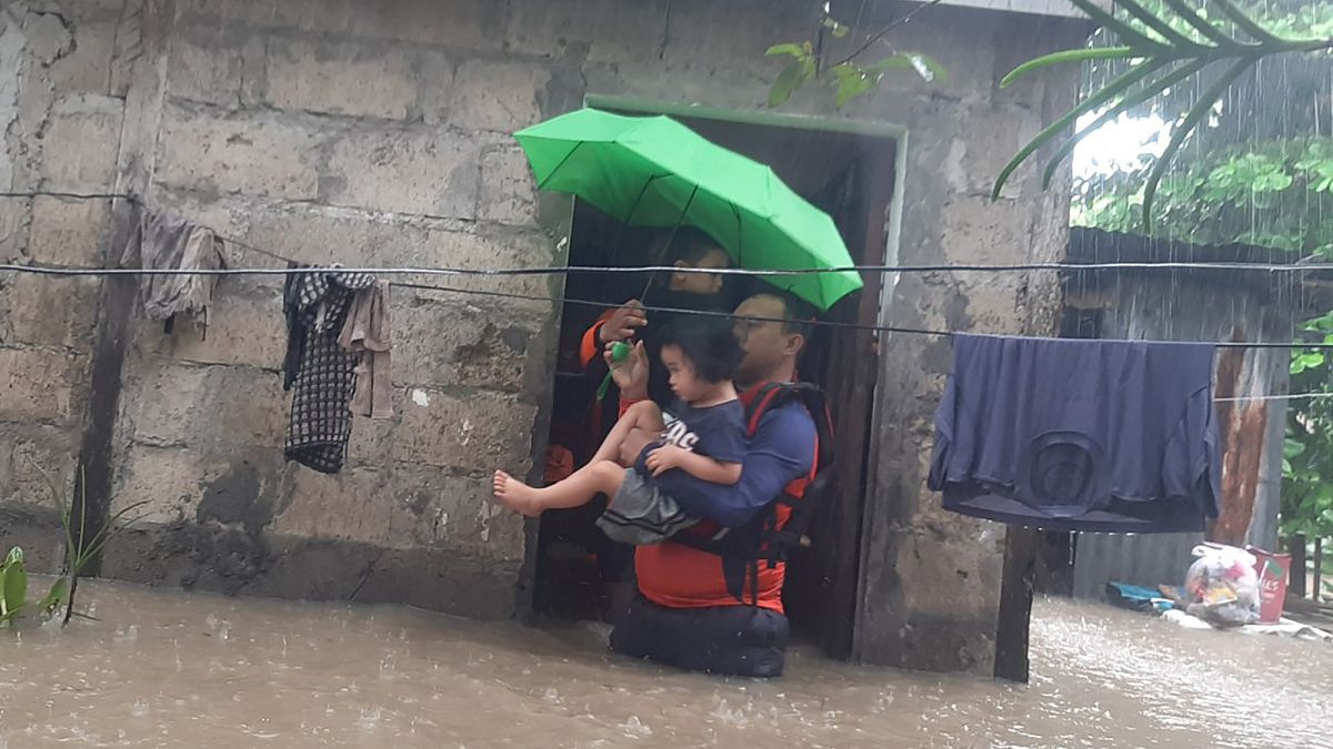 Спасатели проводят эвакуацию из затопленного района в городе Озамиз, провинция Западный Мисамис, 25 декабря 2022 года.