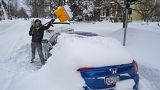Житель Буффало очищает свою машину от снега