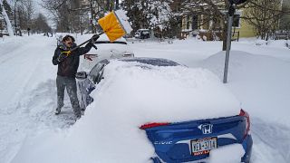 Житель Буффало очищает свою машину от снега