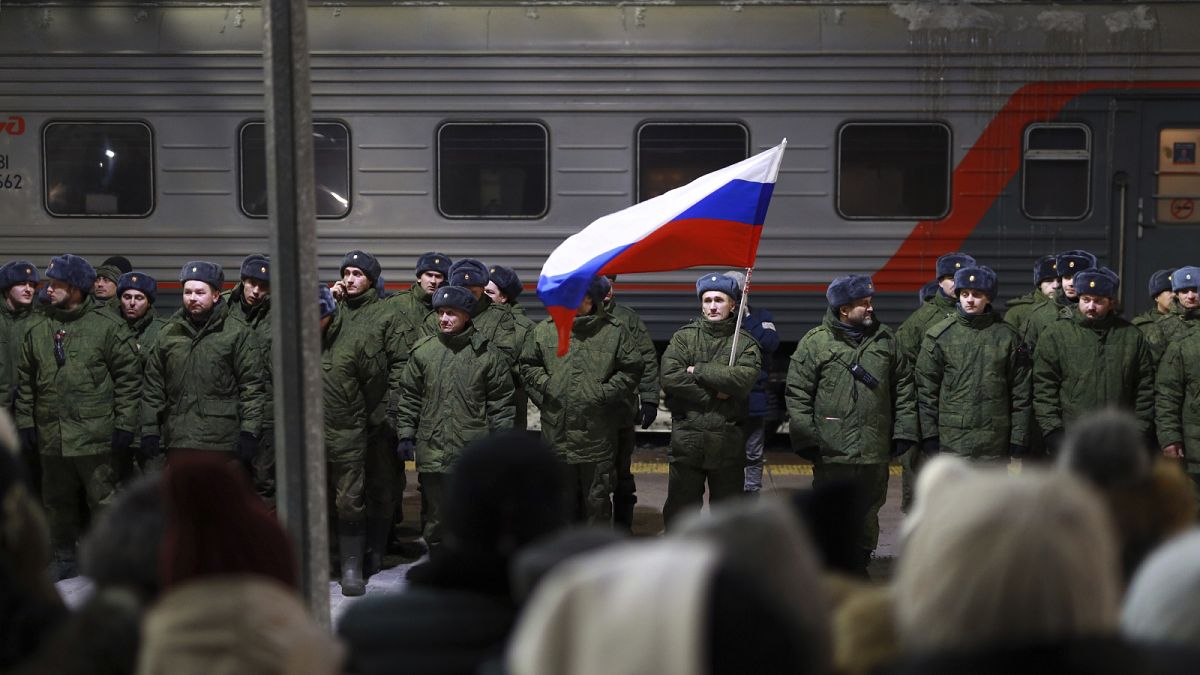 Soldiers who were recently mobilised by Russia for war in Ukraine stand at a ceremony before boarding a train at a railway station in Tyumen, 2 December 2022