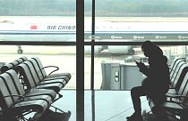 مسافری نشسته در فرودگاه پکن 
