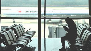 مسافری نشسته در فرودگاه پکن