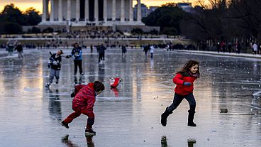 Gyerekek játszanak a befagyott tükörmedence jegén