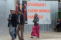 پوستر رجب طیب اردوغان، رئیس جمهور ترکیه در بیرون از یک مرکز رای‌گیری در جریان انتخابات محلی، در دیاربکر ترکیه،۳۱ مارس ۲۰۱۹.
