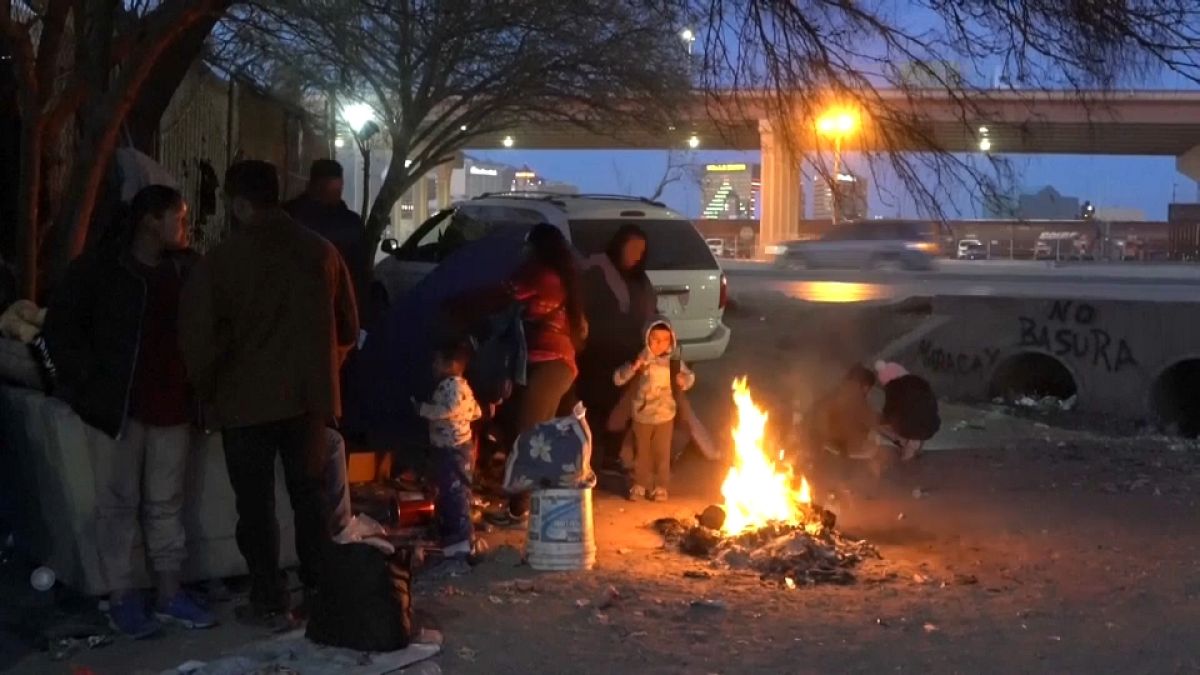 Un grupo de migrantes intenta entrar en calor con una hoguera junto a la frontera