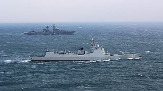Chinese navy destroyer Jinan, foreground, sails along with Russian navy cruiser Varyag during a joint naval drills in the East China Sea on 21 December 2022