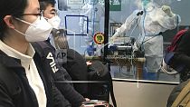 I viaggiatori in arrivo in attesa di un autobus per recarsi in alberghi e fare la quarantena a Guangzhou Baiyun Airport il 25 dicembre 2022.