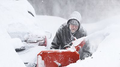 Mike Gippon plows snow in the driveway outside his home in Buffalo on Monday.