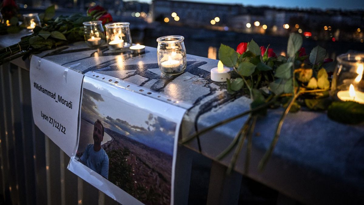 شمع و گل بیاد محمد مرادی بر روی پل رودخانه رون در شه لیون فرانسه ۲۷ دسامبر ۲۰۲۲
