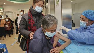 ممرضة تعطي حقنة من لقاح لسيدة مسنة، في نانتونغ في مقاطعة جيانغسو شرق الصين.