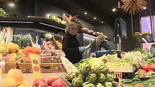 Una mujer atiende en un mercado en España.