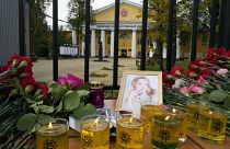 Flowers, candles and a portrait of one of victims are displayed on a table outside the Perm State University.