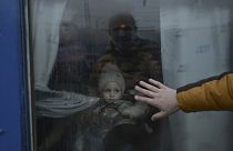 A father puts his hand on the window as he says goodbye to his daughter in front of an evacuation train at the central train station in Odessa on March 7, 2022.