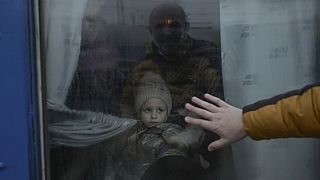 A father puts his hand on the window as he says goodbye to his daughter in front of an evacuation train at the central train station in Odessa on March 7, 2022.