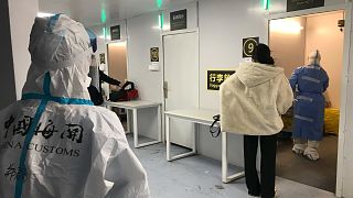 Inbound travelers line up to have samples taken for COVID tests before boarding buses to leave for quarantine hotels and facilities from Guangzhou Baiyun Airport, Dec. 25 2022