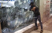 Un manifestante distrugge la vetrina di una banca, durante le proteste contro il governatore della Banca centrale libanese ad Hamra trade street, a Beirut, Libano, 14 gennaio.