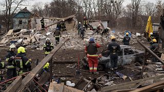 Emergency workers remove debris of a house destroyed following a Russian missile strike in Kyiv.