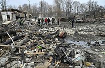 Des sauveteurs enlèvent les débris des maisons détruites par une attaque de missiles dans la banlieue de Kiev, le 29 décembre 2022.