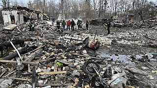 Des sauveteurs enlèvent les débris des maisons détruites par une attaque de missiles dans la banlieue de Kiev, le 29 décembre 2022.