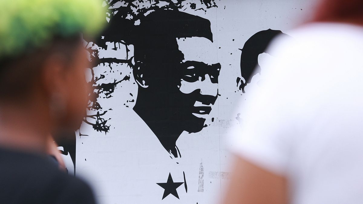 Seguidores de Pelé pasean frente a su imagen en el estadio del Santos brasileño