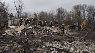 Trabajadores de emergencia retiran los escombros de una casa destruida tras un ataque con misiles rusos en Kiev, Ucrania.