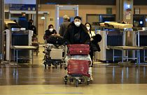 Kínából érkező utazók egy európai reptéren