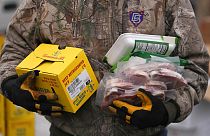 متطوع في بنك الطعام في ولاية يوتا يحمل مواد البقالة للمحتاجين في موقع توزيع مخزن طعام متنقل، 21 ديسمبر، 2022 ،